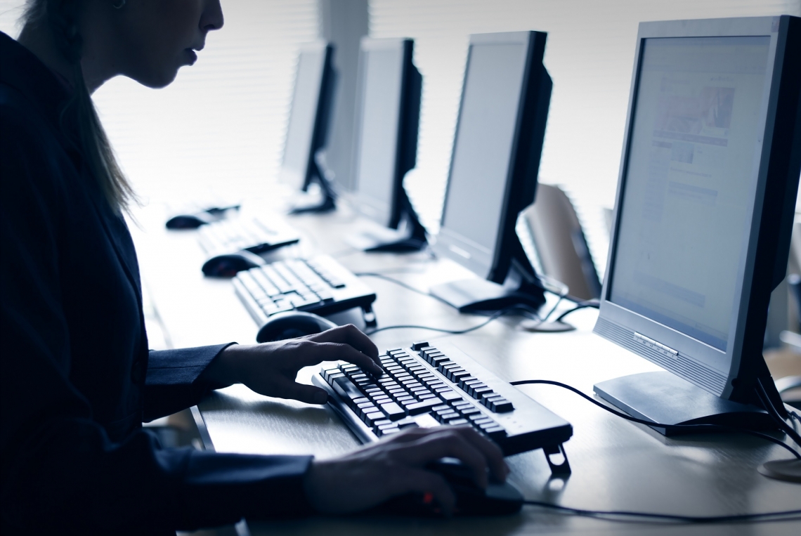 A woman types at a computer Woman at computer