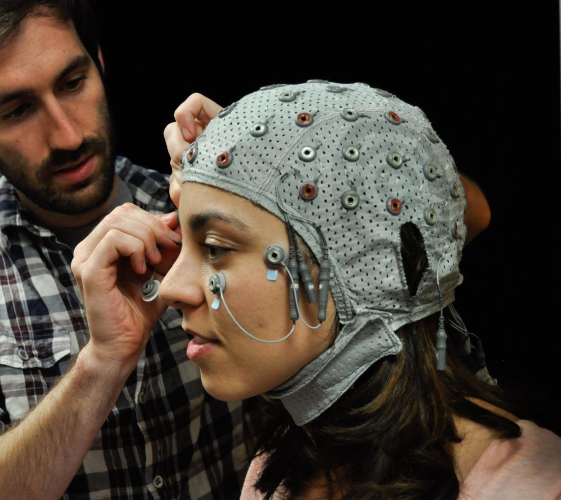 A look inside the mind: Davi Vitela dons a cap used to take EEG scans of her brain activity while she views a series of images. Jay Sanguinetti's study indicates that our minds perceive objects in everyday life of which we are never consciously aware. 