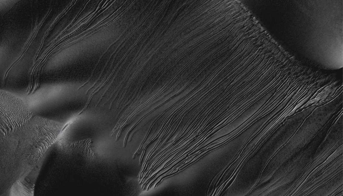This image from the UA-operated HiRISE camera on NASA's Mars Reconnaissance Orbiter shows linear gullies extending almost 1.2 miles inside Russell Crater. Unlike gullies caused by water-lubricated flows on Earth and possibly on Mars, they don't have apron This image from the UA-operated HiRISE camera on NASA's Mars Reconnaissance Orbiter shows linear gullies extending almost 1.2 miles inside Russell Crater. Unlike gullies caused by water-lubricated flows on Earth and possibly on Mars, they don't have apron