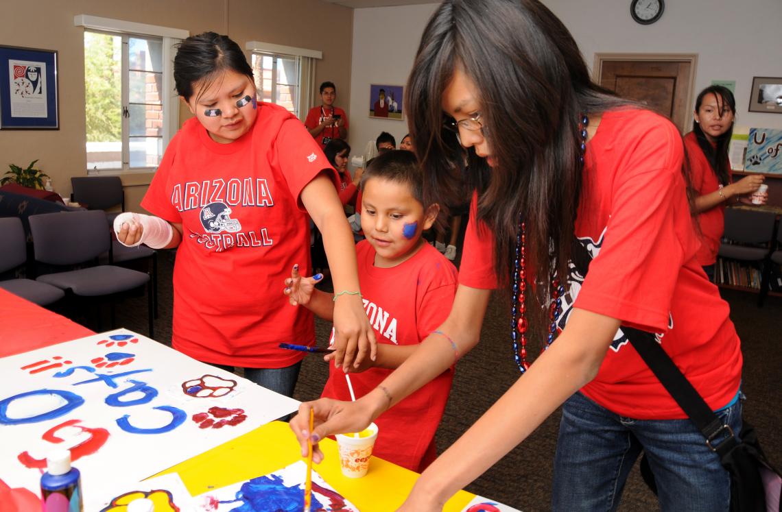 Ashley Scott, 16, , 6-year-old Denim Manygoats and Natasha Manygoats, 12, make posters in support of the football team during NASA Wildcat Family Pride Weekend in 2009.