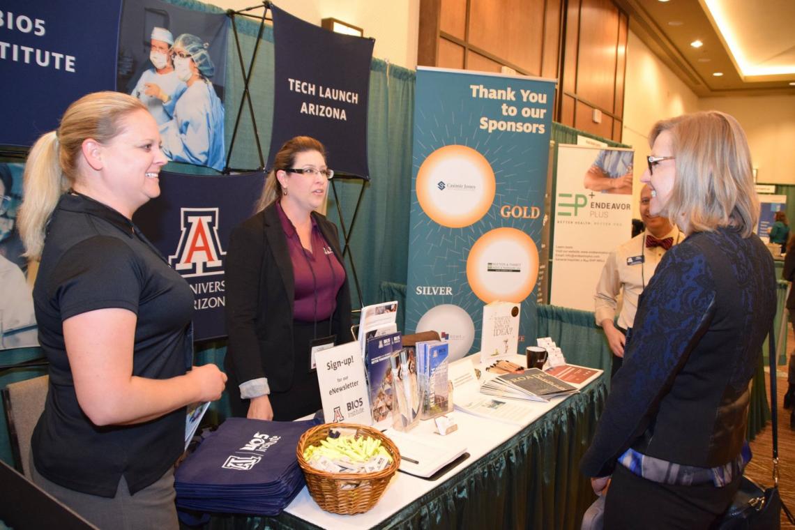 Kelle Hyland and Amy Randall talk with Jennifer Barton at the UA booth at AZBio 2016. The UA's contributions to the bioscience industry have been increasingly significant. 