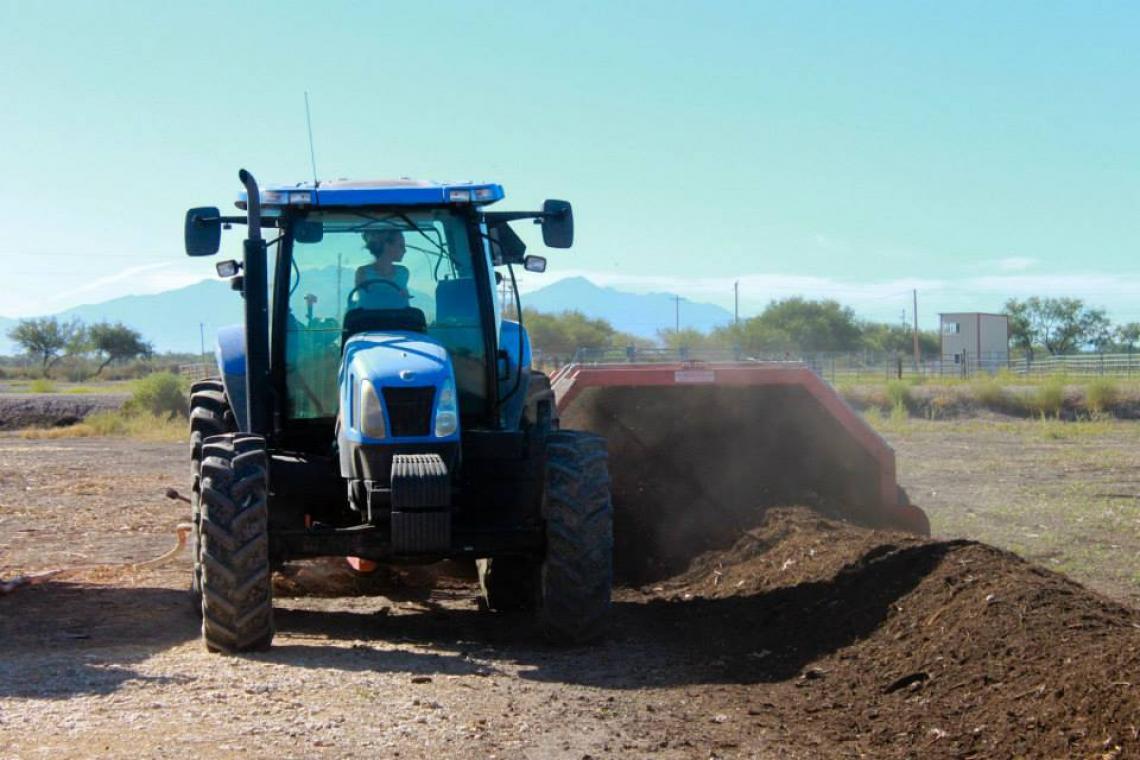 Madeline Ryder, Compost Cats member and UA senior double majoring in natural resources and environmental studies, operates a tractor at San Xavier Co-op Farm as she turns one of the windrows of compost.