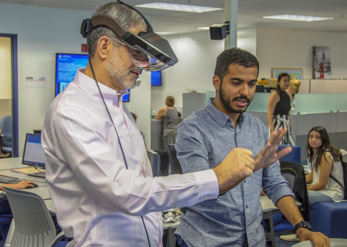 International student Hazza Alkaabi helps UA honorary degree recipient Mohammed Sharaf experience augmented reality. International student Hazza Alkaabi helps UA honorary degree recipient Mohammed Sharaf experience augmented reality.