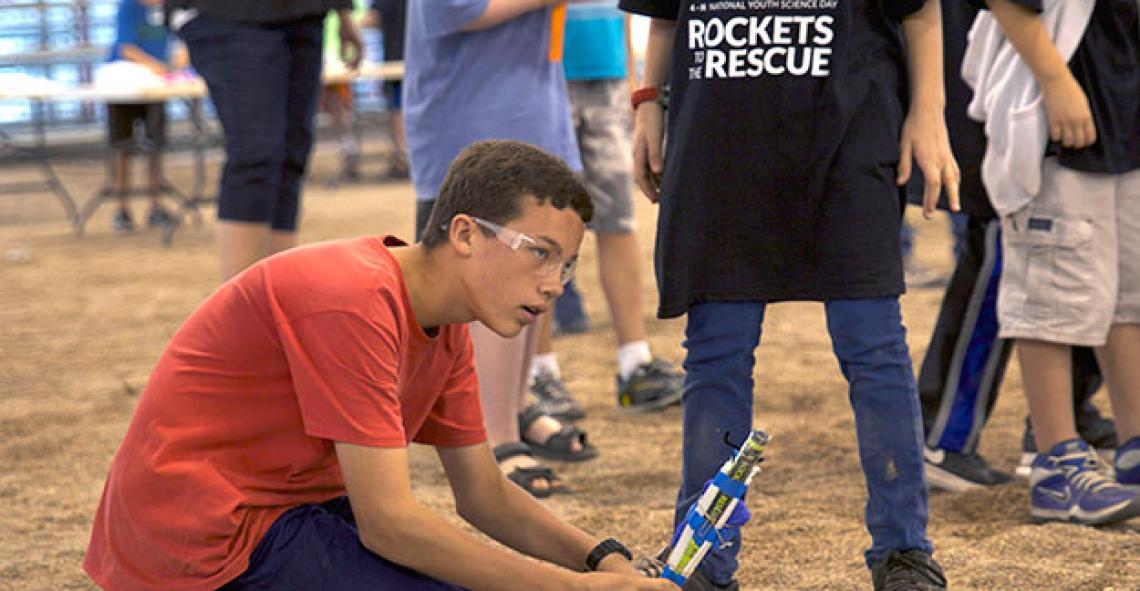 A 4-H National Youth Science Day participant prepares a rocket for launch. 