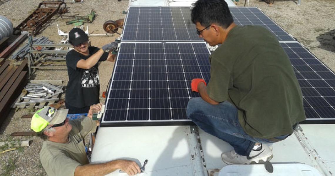 Members of the UA-AATech team mount the solar panels on the roof of the school bus. From left: Bob Seaman, technical lead for desalination unit assembly; environmental engineering master's student Chris Yazzie; and AATech president Peter Zhou. Yazzie was Members of the UA-AATech team mount the solar panels on the roof of the school bus. From left: Bob Seaman, technical lead for desalination unit assembly; environmental engineering master's student Chris Yazzie; and AATech president Peter Zhou. Yazzie was