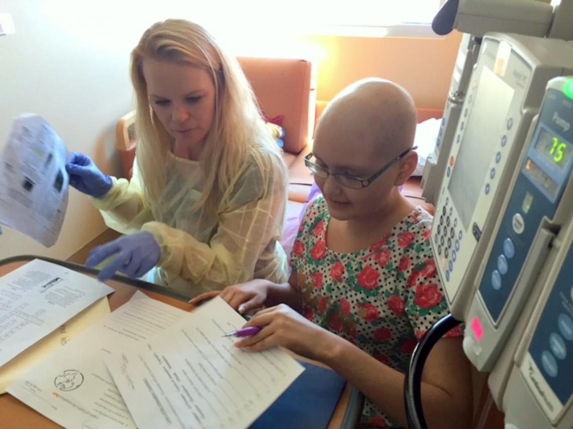 Teacher Ashley Brock reviews homework with Danitza Barra, a patient at Diamond Children's. 