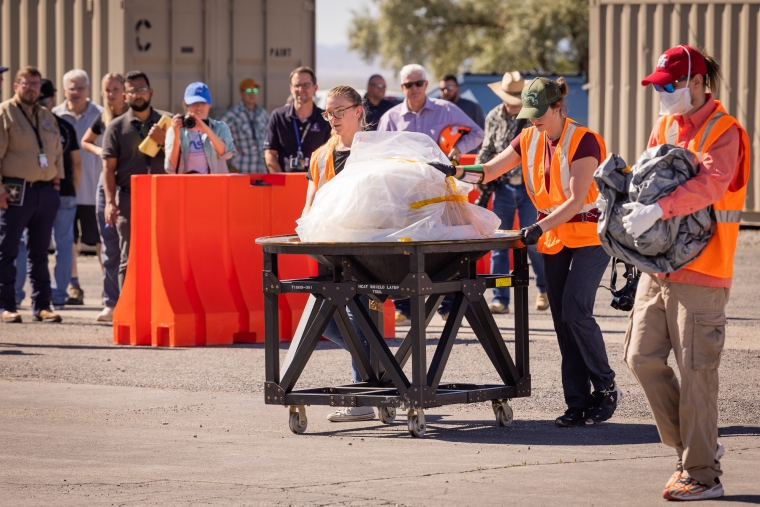 People gather around a mock capsule
