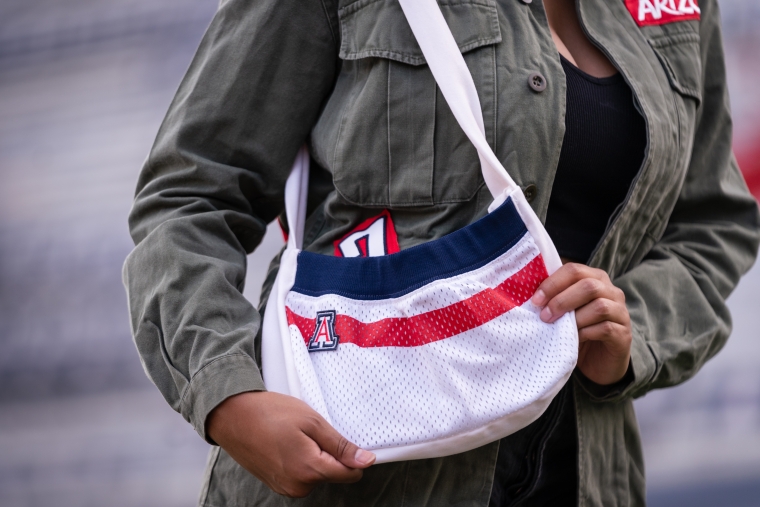 University of Arizona student Erika Gay modeling a handbag made from a retired football jersey Arizona Replay clothing line handbag made from authentic University of Arizona football jersey