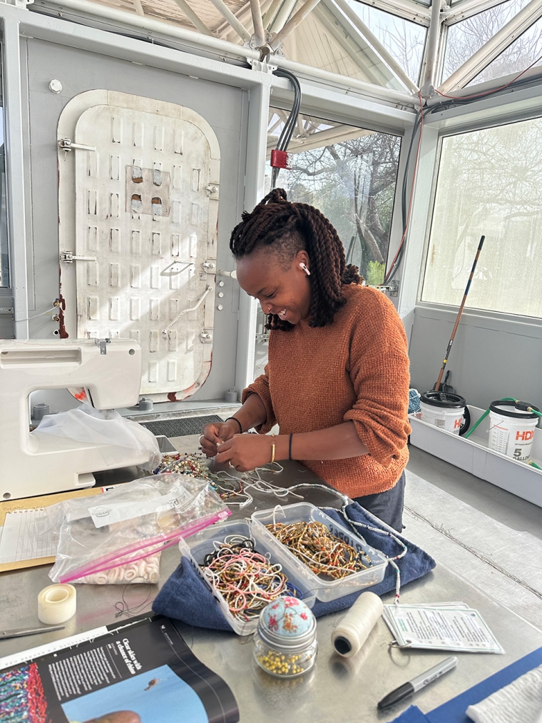 Ivy Wahome works on her creative project in the test module portion of the Space Analog for the Moon and Mars