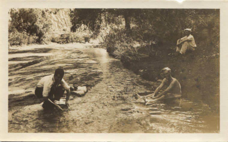 Men sit near the Santa Cruz River