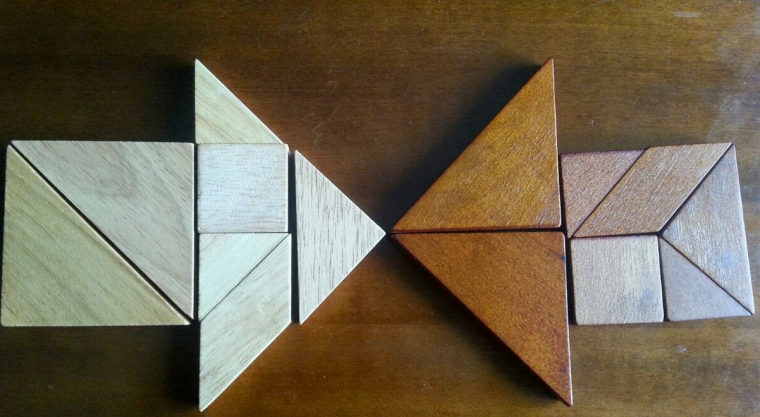 Wooden tangram pieces arranged to form two opposing arrows Wooden tangram pieces arranged to form two opposing arrows