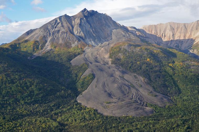 Deceptively similar to a lava flow, the grey mass flowing at the base of Sourdough Peak near McCarthy, Alaska, is actually a glacier blanketed by rocky debris. Jack Holt and his team at the Lunar and Planetary Laboratory have spent years hiking and skiing