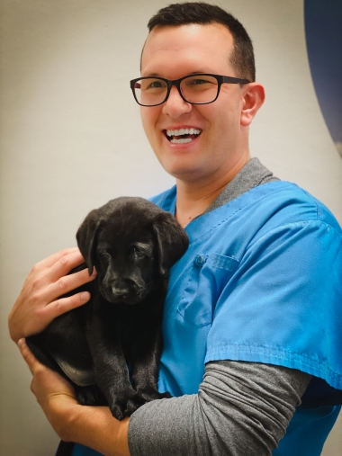 evan maclearn holding a black puppy