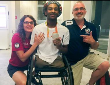 Josh wearing his silver Paralympic medal with his mom and dad, Laura and Matthew Brewer.