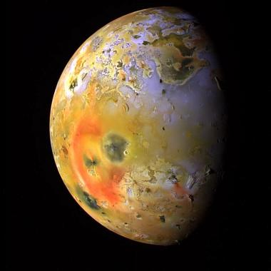 Io illuminated by the sun, with Pele’s red deposits featured prominently. 
